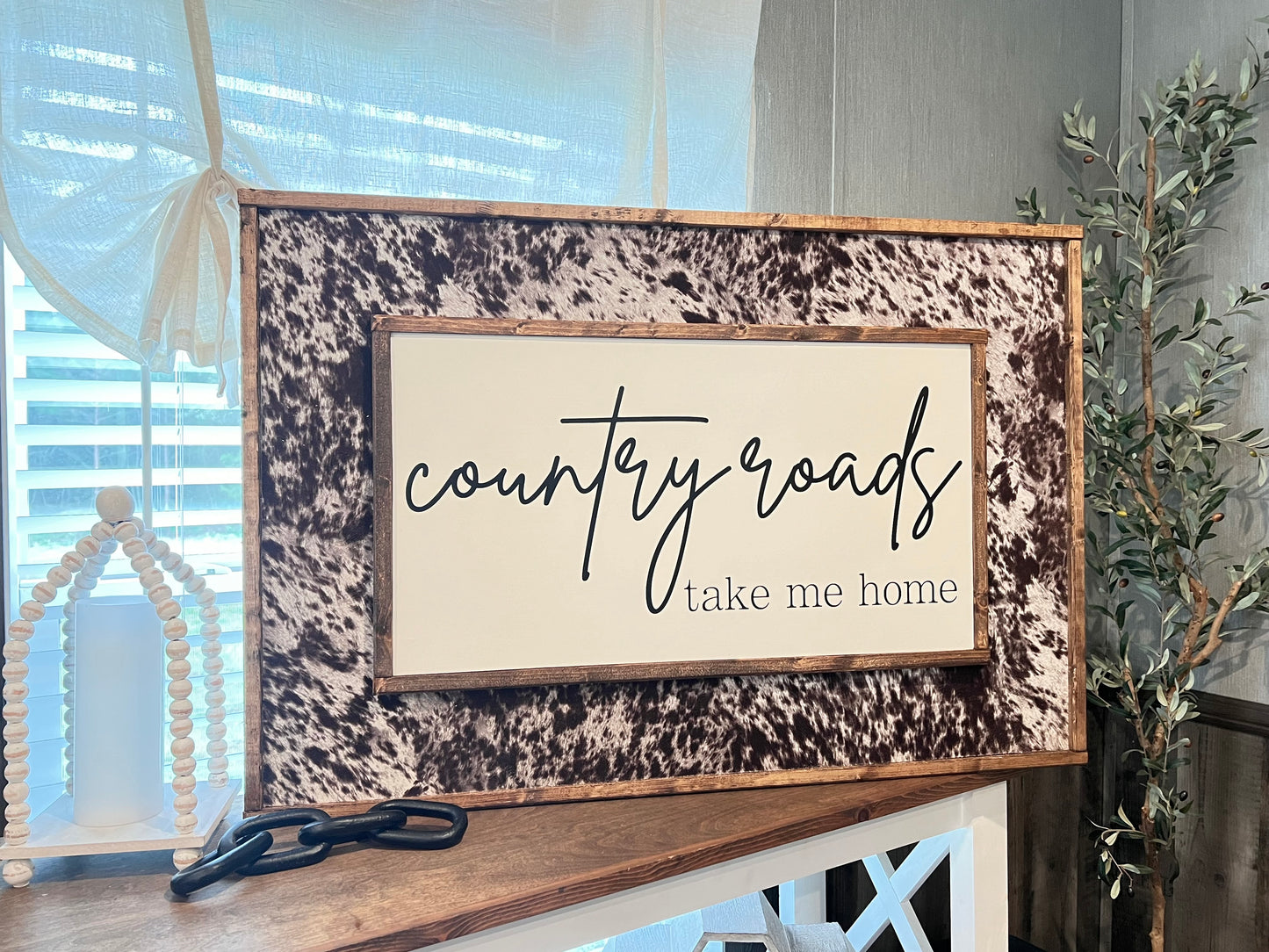 Country roads take me home cowhide wooden sign